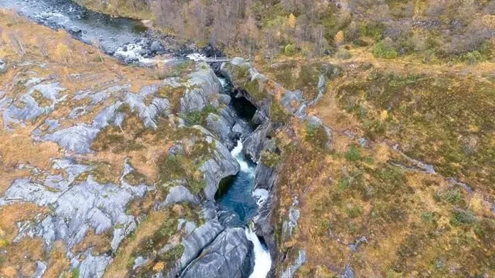 Framed Print : Aerial view of a rocky landscape with a river flowing through a narrow gorge surrounded by autumn foliage