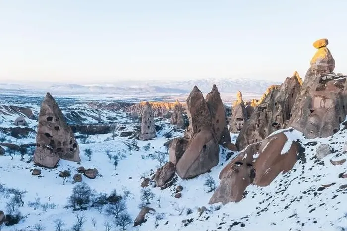 Framed Print : Aerial view of rough rock formations covered with white snow against cloudless evening sky in Cappadocia, Turkey Framed Print : Aerial view of rough rock formations covered with white snow against cloudless evening sky in Cappadocia, Turkey