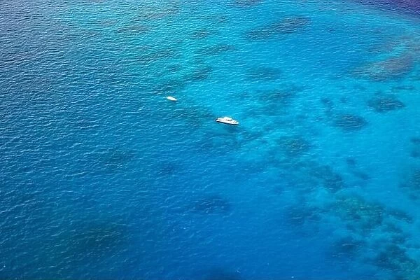 Aerial view sailing boat next to reef. Bird eye view, water sport theme. Snorkel excursion, recreational dive with tourist. Luxury water sport diving