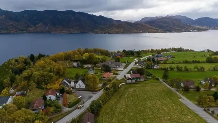 Framed Print : Aerial view of a serene fjord landscape with a small village nestled along the shore Framed Print : Aerial view of a serene fjord landscape with a small village nestled along the shore