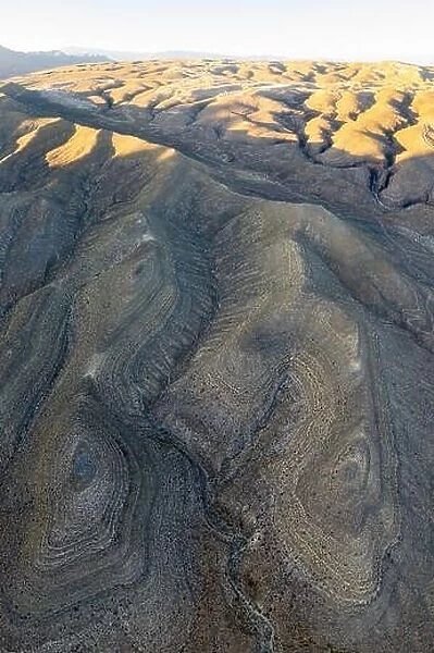 An aerial view shows the rugged, eroded desert landscape that surrounds Las Vegas, Nevada. This desert area averages over 95 degrees F during summer