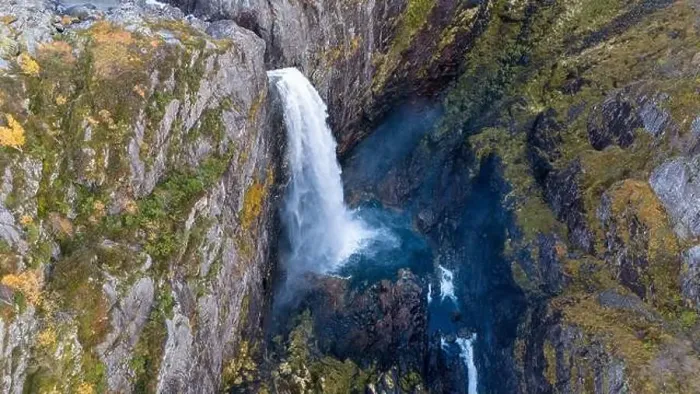 Framed Print : Aerial view of a stunning waterfall cascading down rocky cliffs into a deep blue pool surrounded by lush greenery Framed Print : Aerial view of a stunning waterfall cascading down rocky cliffs into a deep blue pool surrounded by lush greenery