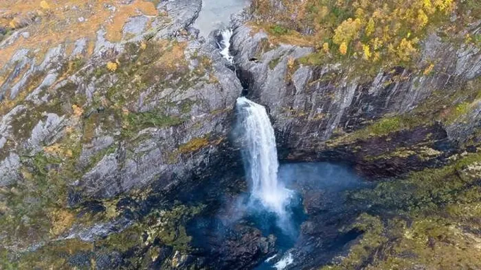 Framed Print : Aerial view of a stunning waterfall cascading down rocky cliffs into a deep blue pool surrounded by lush greenery Framed Print : Aerial view of a stunning waterfall cascading down rocky cliffs into a deep blue pool surrounded by lush greenery