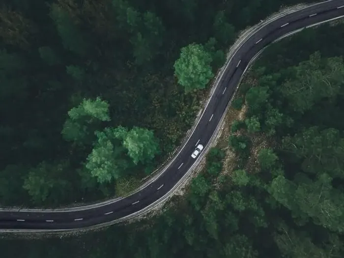 Framed Print : Aerial view taken by drone of a car driving on a forest road in autumn Framed Print : Aerial view taken by drone of a car driving on a forest road in autumn