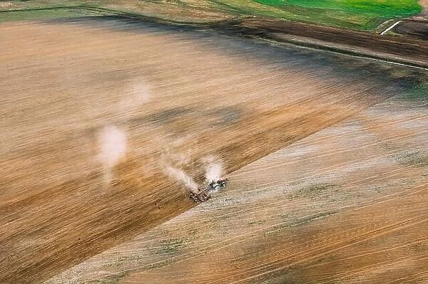 Aerial View. Tractor Plowing Field In Spring Season. Beginning Of Agricultural Spring Season. Cultivator Pulled By A Tractor In Countryside Rural Fiel