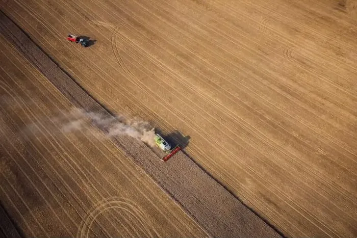 Framed Print : Agricultural machines harvest wheat in the field. Aerial shot from above. There is a lot of dust around the harvester Framed Print : Agricultural machines harvest wheat in the field. Aerial shot from above. There is a lot of dust around the harvester