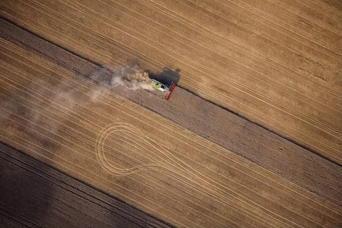Framed Print : Agricultural machines harvest wheat in the field. Aerial shot from above. There is a lot of dust around the harvester Framed Print : Agricultural machines harvest wheat in the field. Aerial shot from above. There is a lot of dust around the harvester