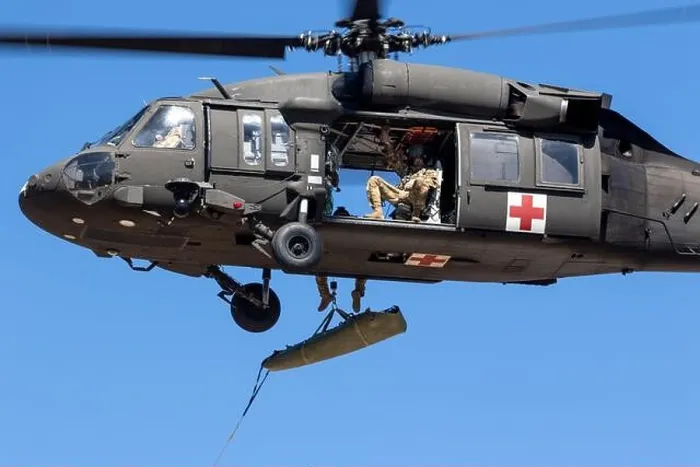 Framed Print : An aircrew assigned to U.S. Army Air Ambulance Detachment- Yakima Training Center conducts a hoist of a simulated SKED litter patient with members of Framed Print : An aircrew assigned to U.S. Army Air Ambulance Detachment- Yakima Training Center conducts a hoist of a simulated SKED litter patient with members of