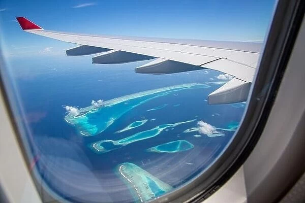 Airplane interior with window view of Maldives island. Concept of travel and air transportation. Maldives islands top view airplane, luxury tourism