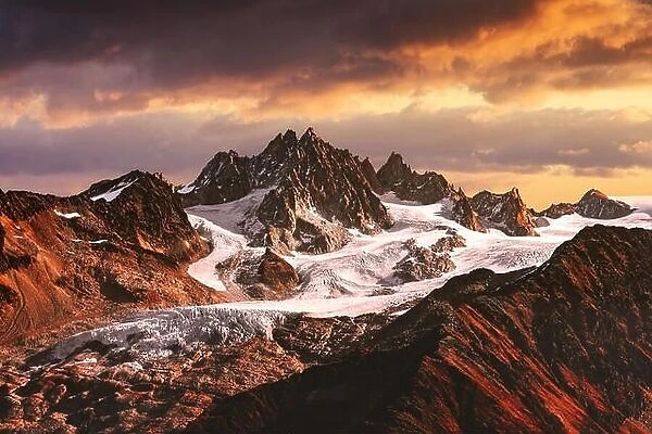 Alpine mountain landscape with glacier and peaks covered by snow