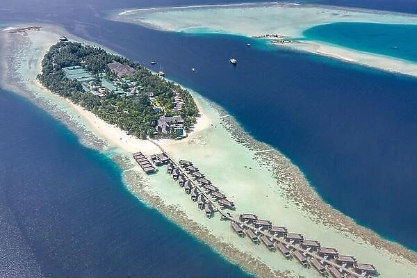 Amazing aerial landscape in Maldives islands. Perfect blue sea and coral reef view from drone or plane. Exotic summer travel and vacation landscape