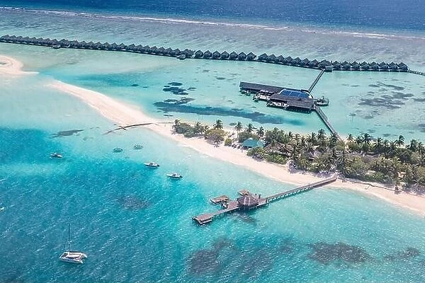 Amazing atoll and island in Maldives from aerial view. Tranquil tropical landscape and seascape with palm trees on white sandy beach, peaceful nature