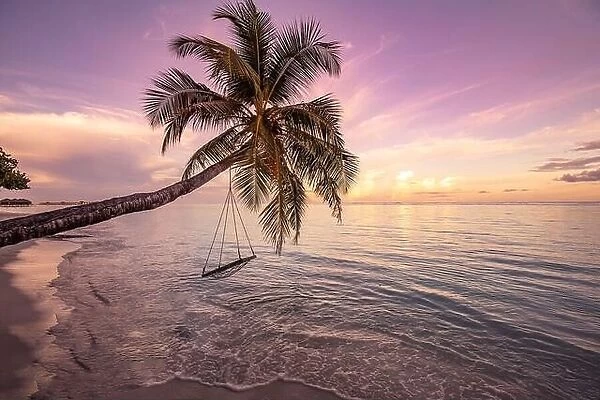 Amazing beach with palm trees and swing at sunset. Beautiful sunset on tropical sea beach background for travel in holiday relax time