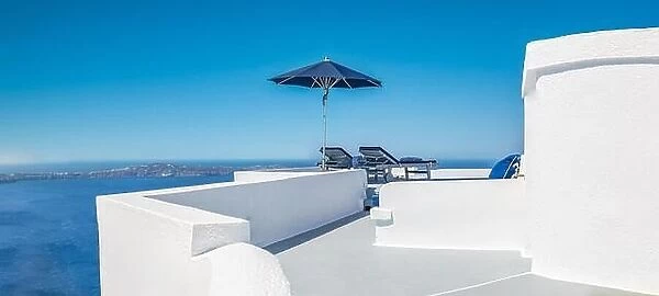 Amazing destination scenic. Two chairs umbrella on caldera terrace in Santorini, Greece. White famous architecture, blue sea sky view. Honeymoon