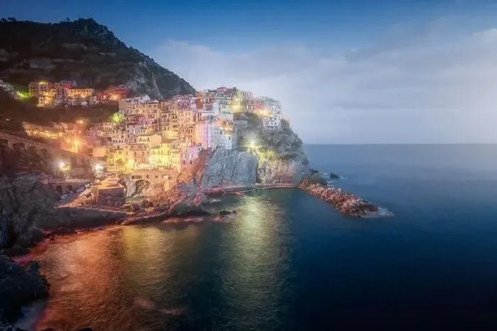 Framed Print : Amazing landscape with small town with colorful lights on rocky coast washing by tranquil ocean water at night Framed Print : Amazing landscape with small town with colorful lights on rocky coast washing by tranquil ocean water at night