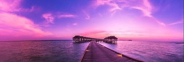 Amazing sunset beach in Maldives, with luxury over water villas and perfect sunset sky. Dreamy summer vacation and holiday concept