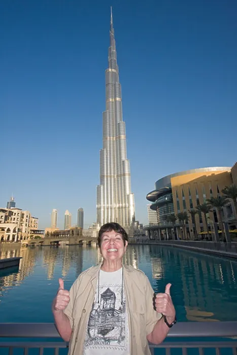 Framed Print : American visitor poses in front of Burj Khalifa, tallest man made structure ever built Framed Print : American visitor poses in front of Burj Khalifa, tallest man made structure ever built