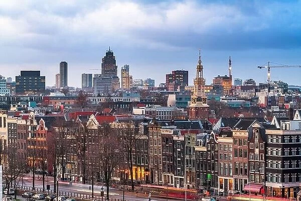 Amsterdam, Netherlands historic cityscape with the modern Zuidas district in the distance at dusk