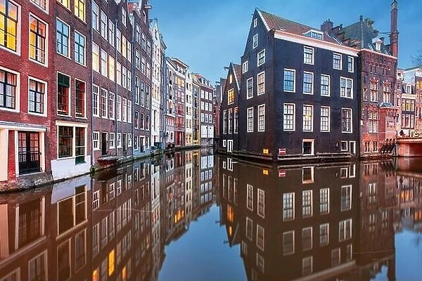 Amsterdam, Netherlands with narrow canals and buildings lining them in the morning time