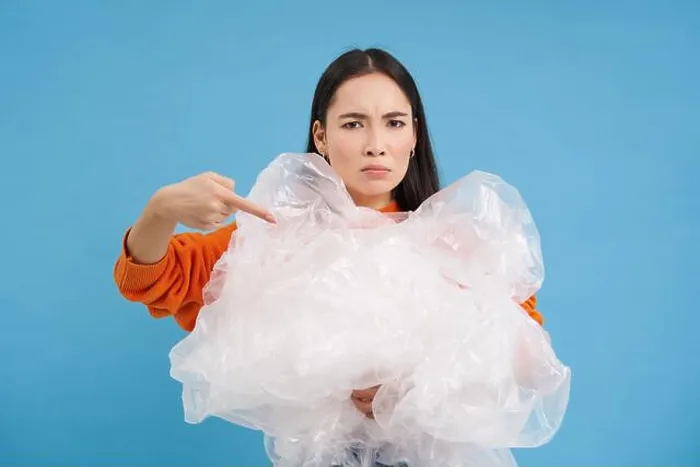 Framed Print : Angry eco-activist points at big pile of plastic bags Framed Print : Angry eco-activist points at big pile of plastic bags
