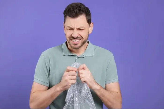 Framed Print : Angry man popping bubble wrap on purple background. Stress relief Framed Print : Angry man popping bubble wrap on purple background. Stress relief