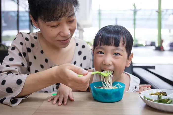 Framed Print : Asian Chinese mother and daughter eating beef noodles in outdoor cafe Framed Print : Asian Chinese mother and daughter eating beef noodles in outdoor cafe