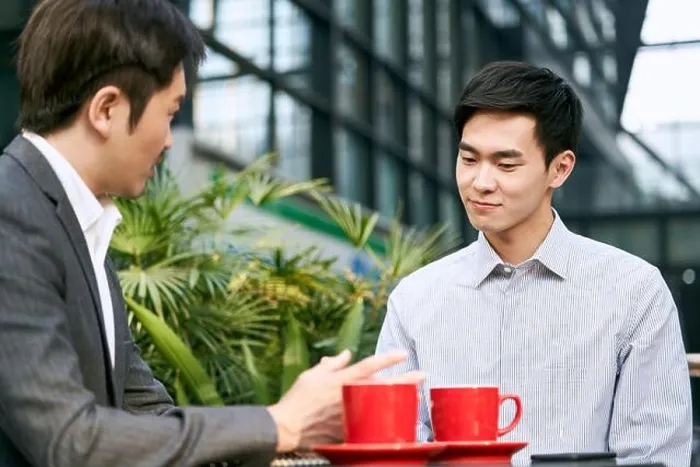 Framed Print : two asian corporate businesspeople discussing business at a outdoor coffee shop Framed Print : two asian corporate businesspeople discussing business at a outdoor coffee shop