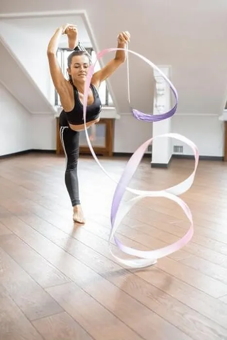Framed Print : Athletic woman practising rhythmic gymnastics with a ribbon in the gym Framed Print : Athletic woman practising rhythmic gymnastics with a ribbon in the gym