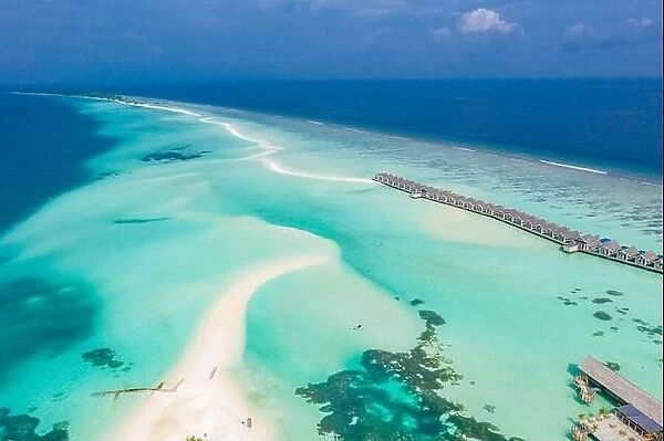 Atolls and islands in Maldives with jetty and over water villas. Luxury summer holiday vacation, white sand, blue sea, idyllic tropical island beach