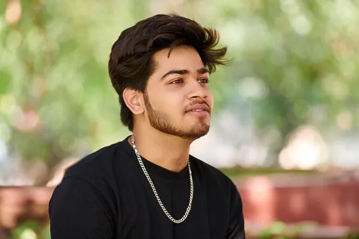 Framed Print : Attractive young indian man portrait in black t shirt and silver neck chain on outdoor green park background Framed Print : Attractive young indian man portrait in black t shirt and silver neck chain on outdoor green park background