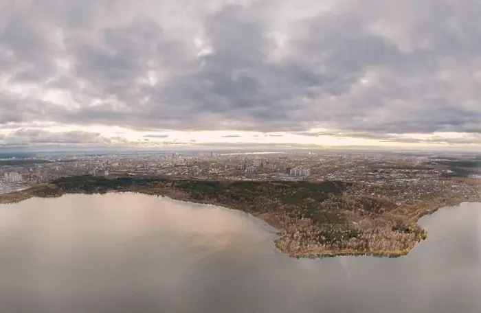 Framed Print : Autumn forest on lake shore at sunset and city on horizon, aerial view. Lake Shartash and Yekaterinburg, Russia Framed Print : Autumn forest on lake shore at sunset and city on horizon, aerial view. Lake Shartash and Yekaterinburg, Russia