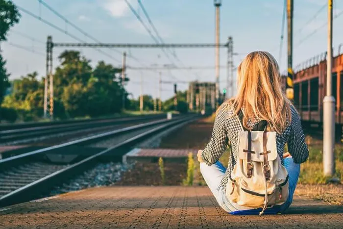 Framed Print : Backpacker woman sitting on railway station platform and waiting for train. Traveling in Europe during summer Framed Print : Backpacker woman sitting on railway station platform and waiting for train. Traveling in Europe during summer