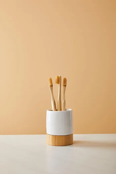 Framed Print : bamboo toothbrushes in holder on white table and beige background Framed Print : bamboo toothbrushes in holder on white table and beige background