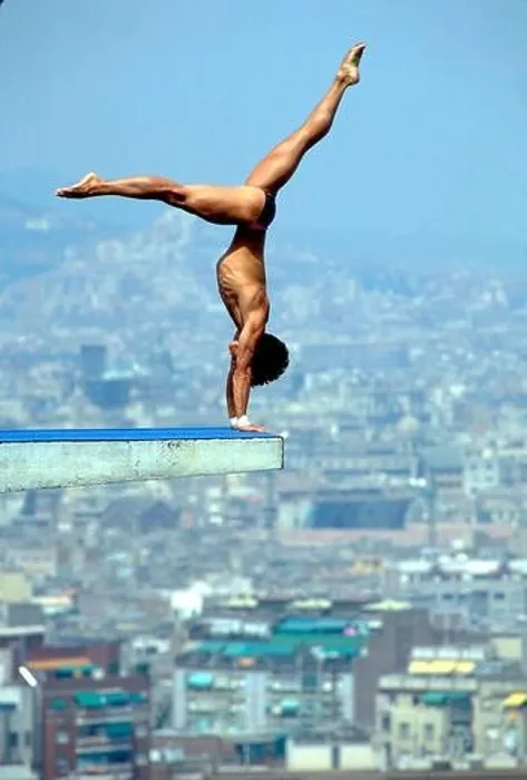 Framed Print : Barcelona, Spain: Male diver performs handstand on 10-meter platform at beginning of his dive, with the Barcelona skyline in the background Framed Print : Barcelona, Spain: Male diver performs handstand on 10-meter platform at beginning of his dive, with the Barcelona skyline in the background