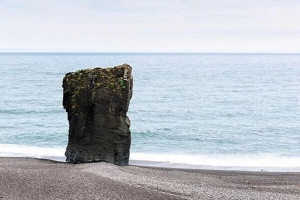 Alone basalt rock on Iceland coastline. Landscape photography