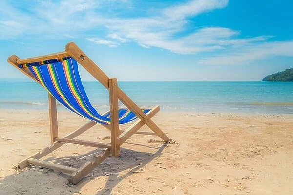 One beach chairs on the white sand with blue sky and summer sea background. Summer, Vacation, Travel and Holiday concept