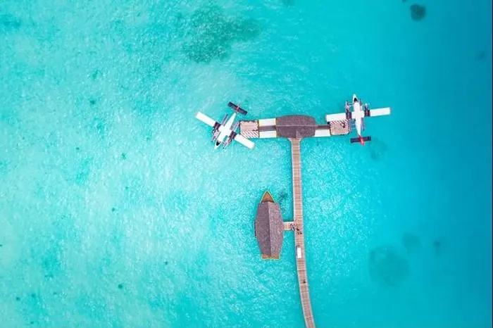 Framed Print : Beautiful aerial view of Maldives jetty seaplane top view with wooden boat Dhoni and tropical beach, jetty over wonderful blue sea. Luxury travel