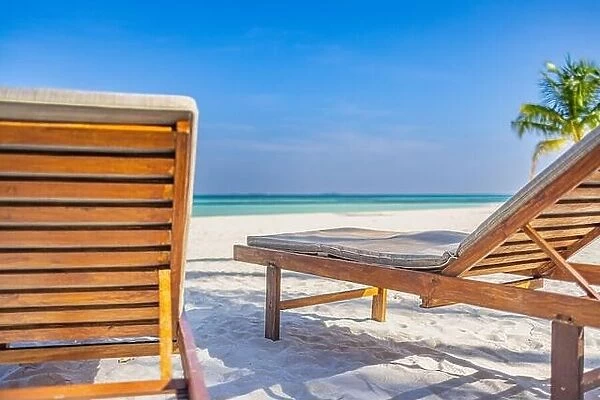 Beautiful beach. Couple chairs on the sandy beach near the sea, blurred island landscape exotic shore coast. Summer holiday and dream vacation concept