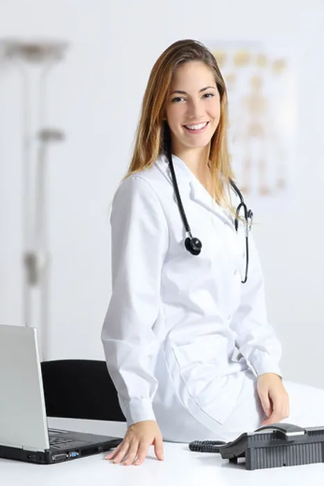 Framed Print : Beautiful female doctor sitting on the desk of her consultation Framed Print : Beautiful female doctor sitting on the desk of her consultation