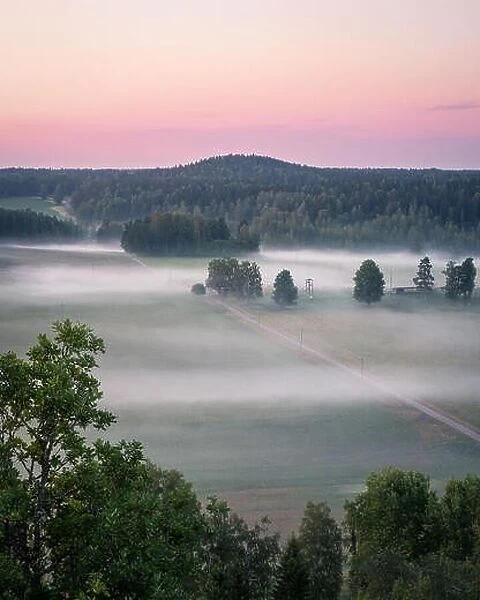 Beautiful landscape view with fog and meadow at summer evening in countryside, Finland