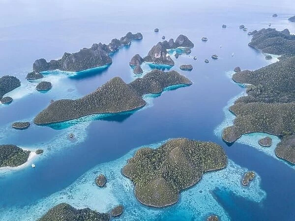 Beautiful limestone islands are fringed by coral reefs in Wayag, Raja Ampat, Indonesia. This region is known for its amazing marine biodiversity