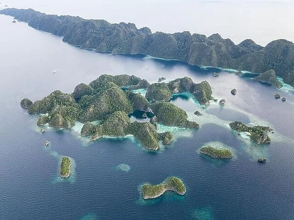 Beautiful limestone islands rise from the calm seas of Raja Ampat, Indonesia. This remote region is known for its extraordinary marine biodiversity