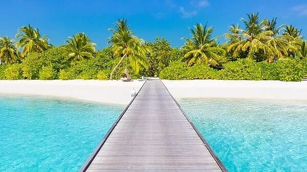 Beautiful Maldives island scene, wooden jetty into palm trees and paradise island. Luxury summer beach vacation and holiday concept. Exotic lifestyle
