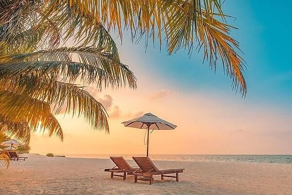 Beautiful Maldives island, sunset beach landscape. Luxury resort chairs and umbrella for summer vacation and holiday background. Exotic tropical beach