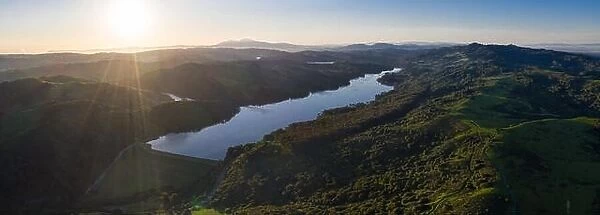 A beautiful morning lights the green hills around the San Pablo Reservoir in Northern California. A wet winter has caused lush vegetation growth