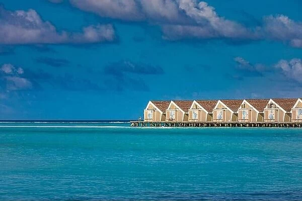 Beautiful ocean lagoon with water bungalows at Maldives, sunny blue cloudy sky. relax tropical vacation, holiday landscape