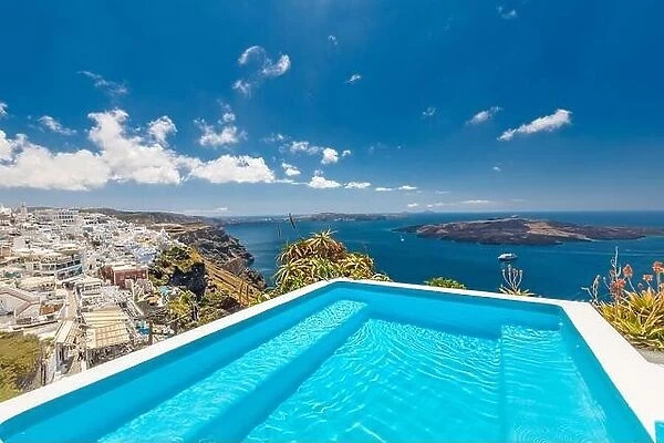 Beautiful resort on the island of Santorini. View of caldera and swimming pool in foreground, typical white architecture, amazing travel landscape