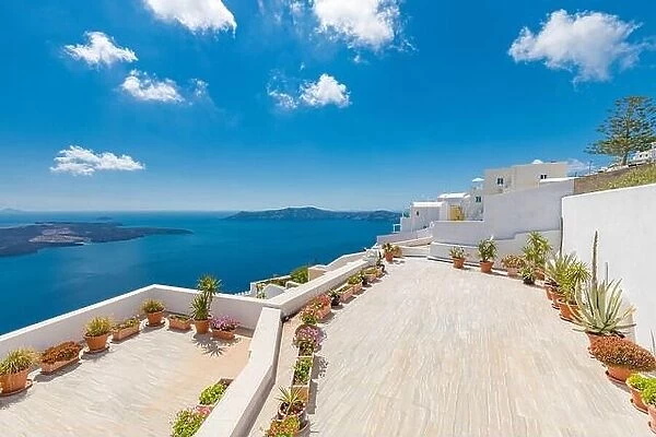 Beautiful terrace in Santorini with breathtaking view. Flowers pots with picturesque view of traditional cycladic Santorini houses
