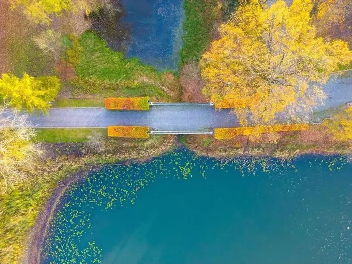 Framed Print : Beautiful travel or tourism style look down aerial of pedestrian foot bridge across River at park with colorful fall Framed Print : Beautiful travel or tourism style look down aerial of pedestrian foot bridge across River at park with colorful fall
