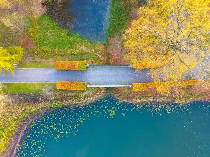 Framed Print : Beautiful travel or tourism style look down aerial of pedestrian foot bridge across River at park with colorful fall Framed Print : Beautiful travel or tourism style look down aerial of pedestrian foot bridge across River at park with colorful fall